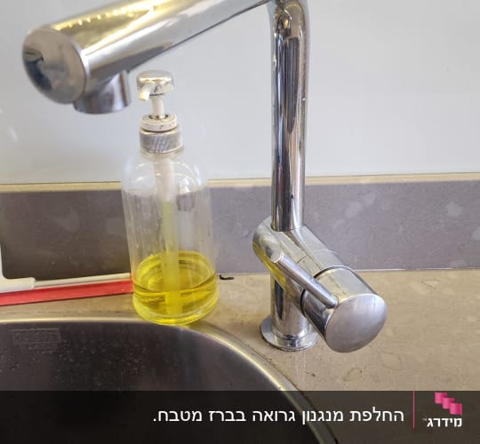 ברז נירוסטה עם סבון ליד כיור מטבח